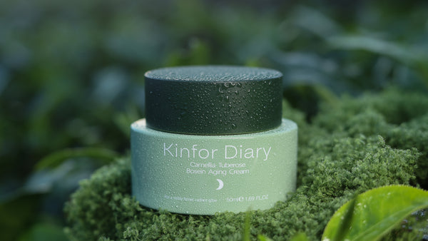Cosmetic jar labeled 'Kinfor Diary' on a green leafy background