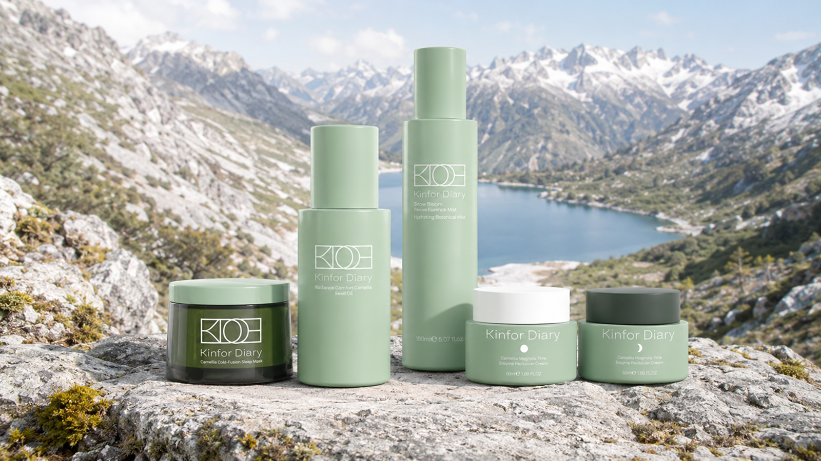 A set of Kiehl skincare products in sage green and dark green packaging stands on a rocky ledge with a dramatic mountain and lake landscape in the background.